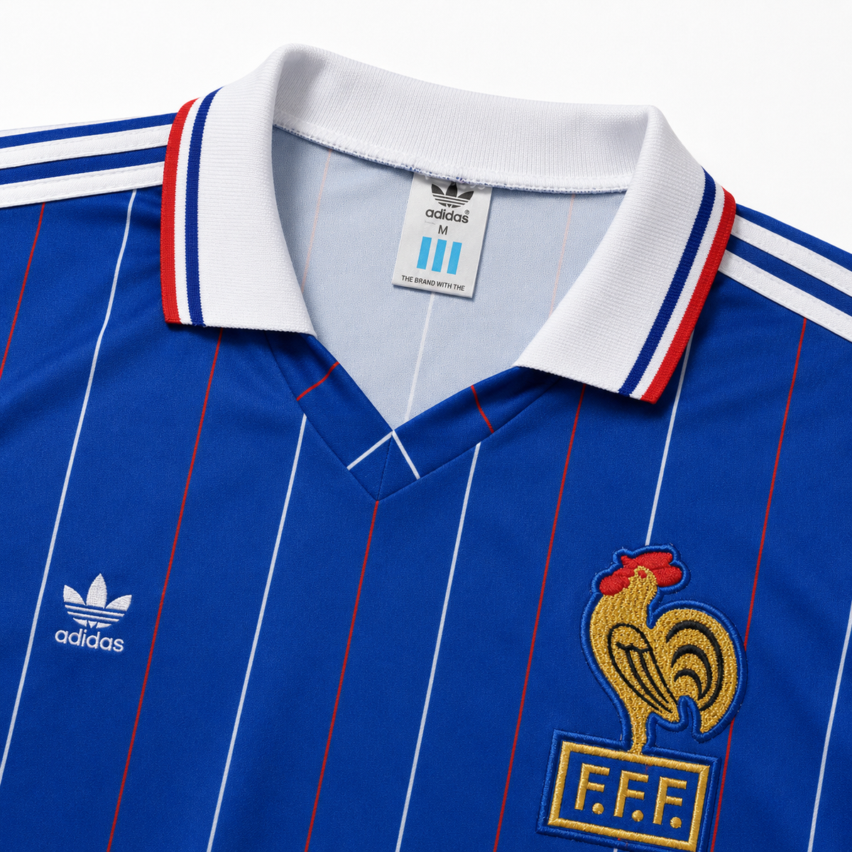 Détail du col blanc en V et de l'écusson coq FFF brodé du maillot France 1982